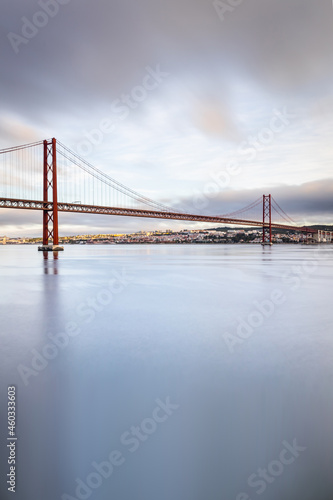 the 25 de Abril suspension bridge over Tagus river in Lisbon, Portugal at sunrise photo