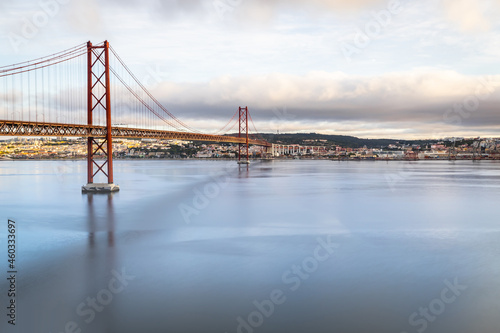 the 25 de Abril suspension bridge over Tagus river in Lisbon, Portugal at sunrise