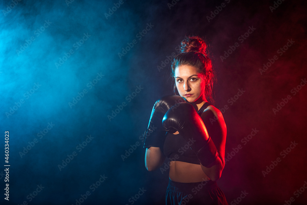 Young woman doing boxing training at the gym, she is wearing boxing gloves