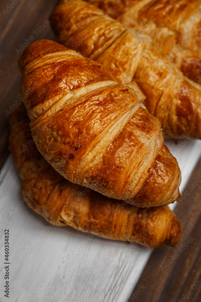 Croissant on wooden board - freshly baked pastry