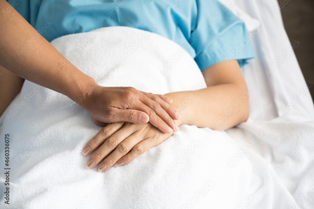 Close up doctor taking patients hand on the bed in hospiital.Nurse hand