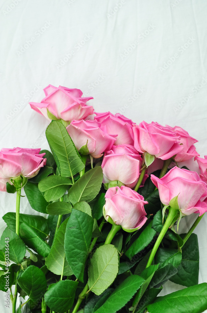 Bouquet of pink roses on the white linens on bed Bouquet of pink roses on the white linens on bed