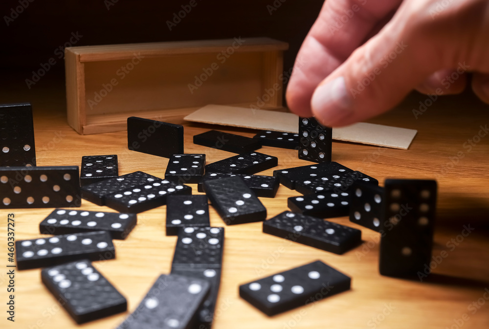 Domino game pieces scattered on wooden desk with wood box. Domino game pieces scattered on wooden desk with wood box.