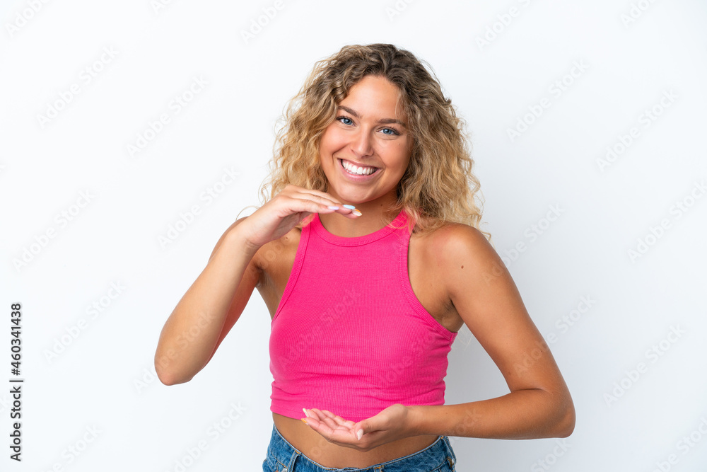 Girl with curly hair isolated on white background holding copyspace imaginary on the palm to insert an ad Girl with curly hair isolated on white background holding copyspace imaginary on the palm to insert an ad