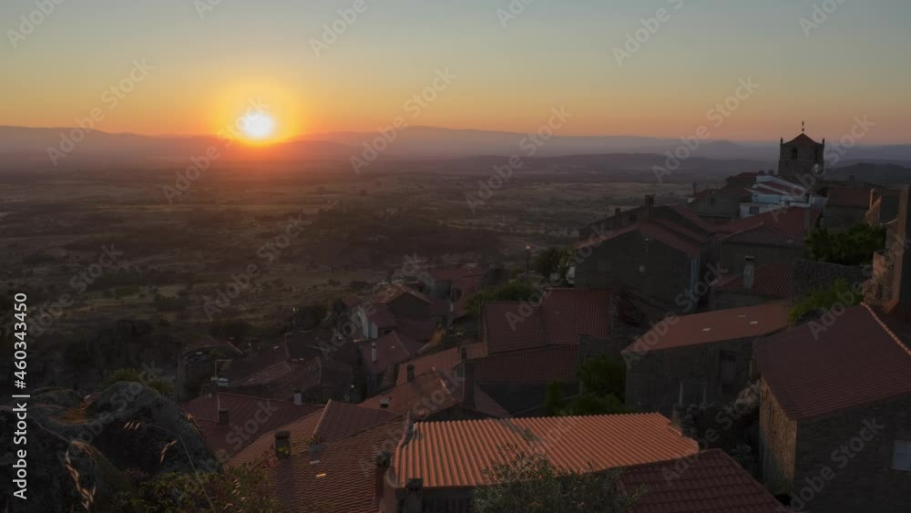 Time-lapse of sun disappearing on horizon over mountain at sunset, Monsanto in Portugal Time-lapse of sun disappearing on horizon over mountain at sunset, Monsanto in Portugal
