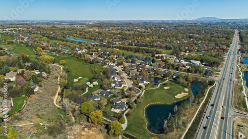 Drone aerial view of a golf course in Eagle, Idaho surrounded by a residential neighborhood and a busy road photo