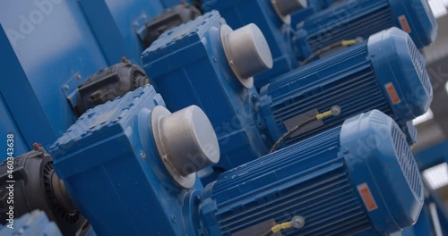 Rows of blue powerful industrial motors in the processing line of a new modern plant 