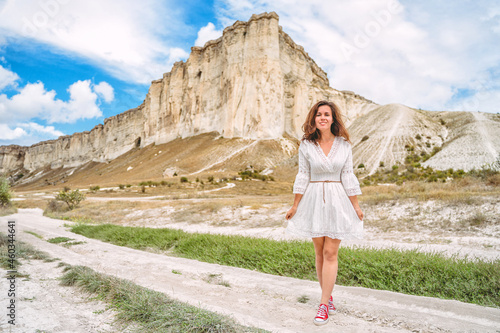 A beautiful young woman in a white dress at the foot of a White Rock in the Crimea. A beautiful concept of purity and magic. © KseniaJoyg
