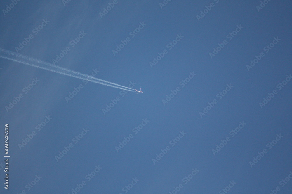 Flugzeug am blauen Himmel mit Kondensstreifen Flugzeug am blauen Himmel mit Kondensstreifen