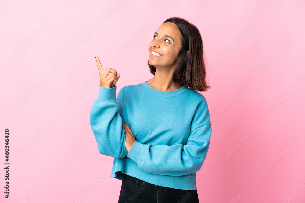 Young latin woman isolated on pink background pointing up a great idea Young latin woman isolated on pink background pointing up a great idea