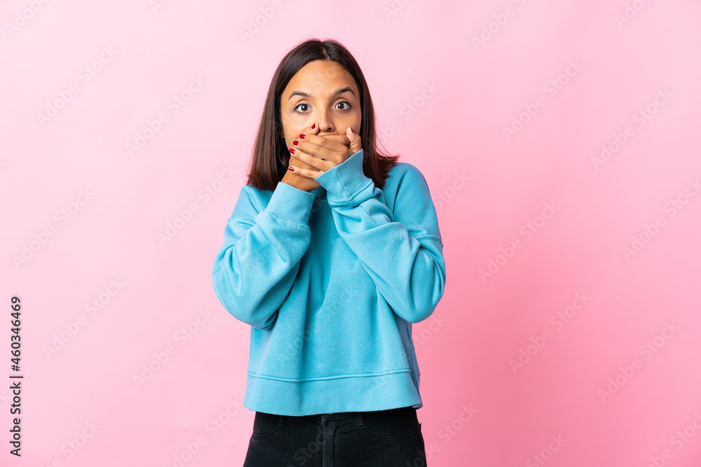Young latin woman isolated on pink background covering mouth and looking to the side Young latin woman isolated on pink background covering mouth and looking to the side