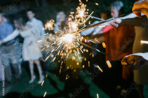 A big Bengal fire burning against a backdrop of sky and nature. holding sparklers and fireworks.  Blurred background and soft focus.