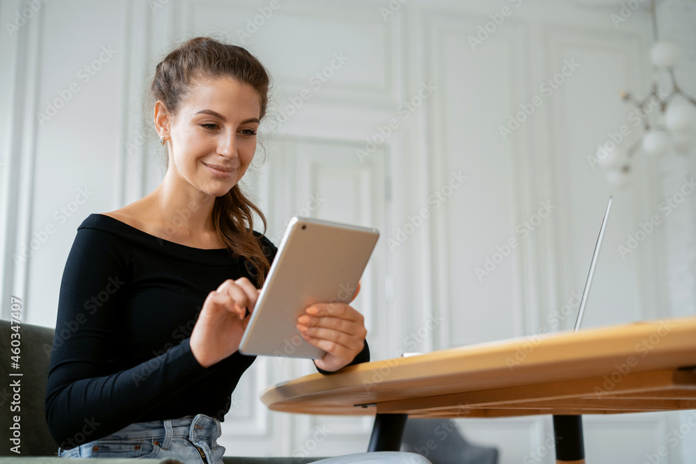 Portrait of a freelance woman at home workplace. Manager work office in coworking. Designer surf the Internet on a gadget. The financier responds to clients' emails. Portrait of a freelance woman at home workplace. Manager work office in coworking. Designer surf the Internet on a gadget. The financier responds to clients' emails.
