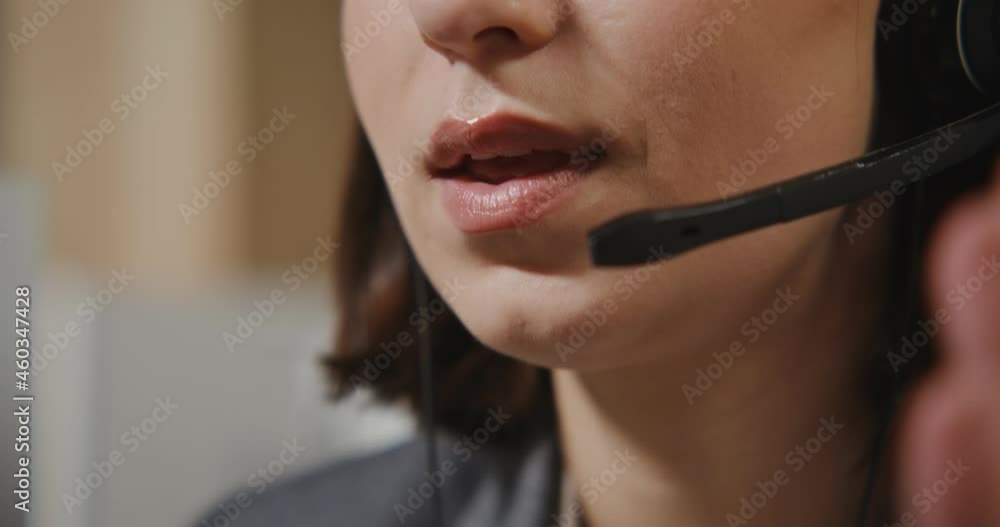 Call center worker - a young man in headphones communicates with a client Call center worker - a young man in headphones communicates with a client