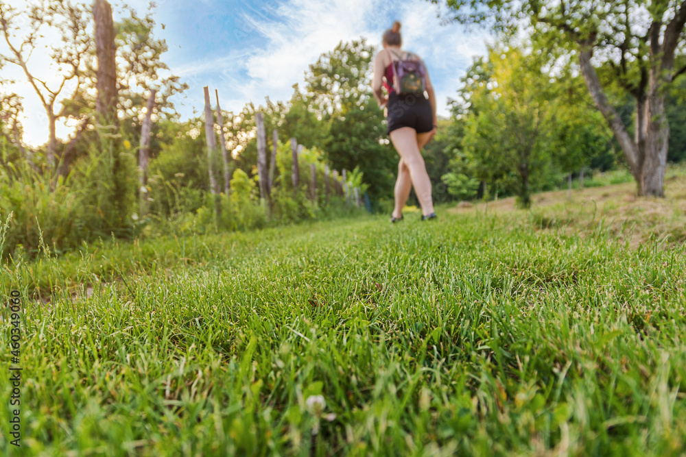 Woman trail climbing on countryside with grass focused