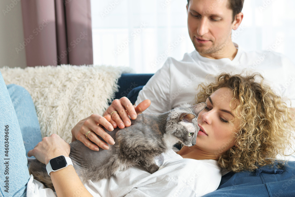 Young couple with their lovely cat relaxing at home Young couple with their lovely cat relaxing at home