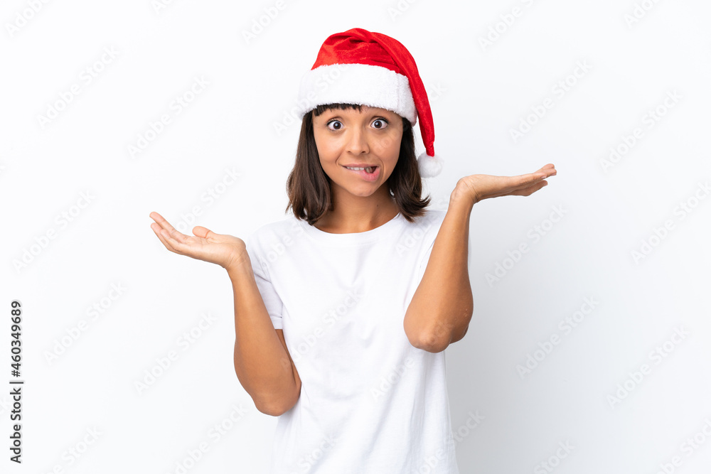 Young mixed race woman celebrating Christmas isolated on white background having doubts while raising hands Young mixed race woman celebrating Christmas isolated on white background having doubts while raising hands