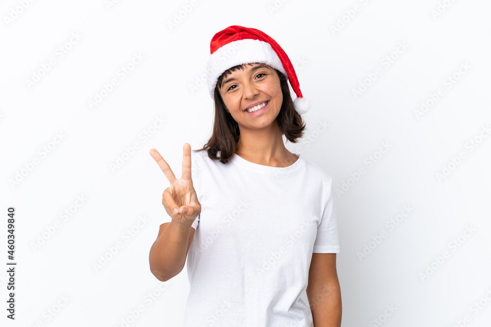 Young mixed race woman celebrating Christmas isolated on white background smiling and showing victory sign Young mixed race woman celebrating Christmas isolated on white background smiling and showing victory sign