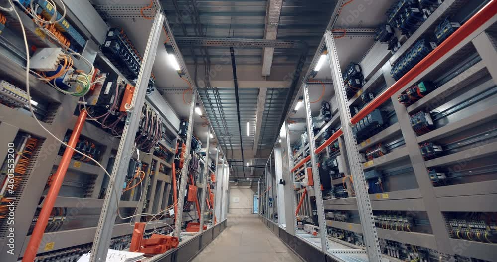 Industrial equipment control room corridor with many wires, electrical parts, automatic switches, breakers, residual current devices, fuses, terminals 