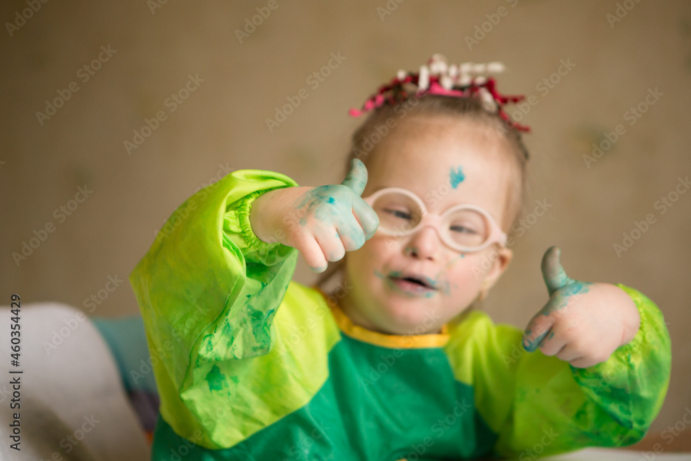 Girl with Down syndrome covered in paint when drawing Girl with Down syndrome covered in paint when drawing