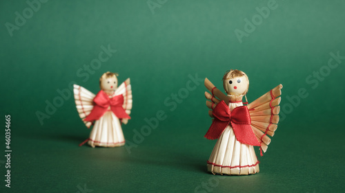 Straw Angels and Green Background. Decorations for Christmas and New Year