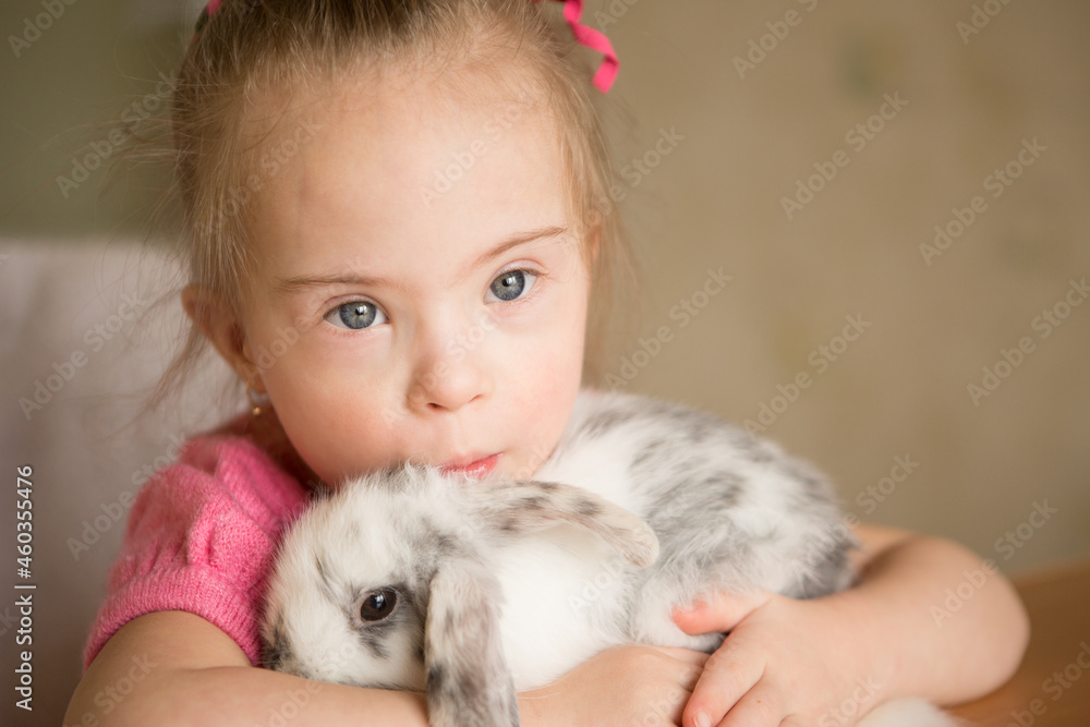 Girl with Down syndrome hugs rabbit Girl with Down syndrome hugs rabbit