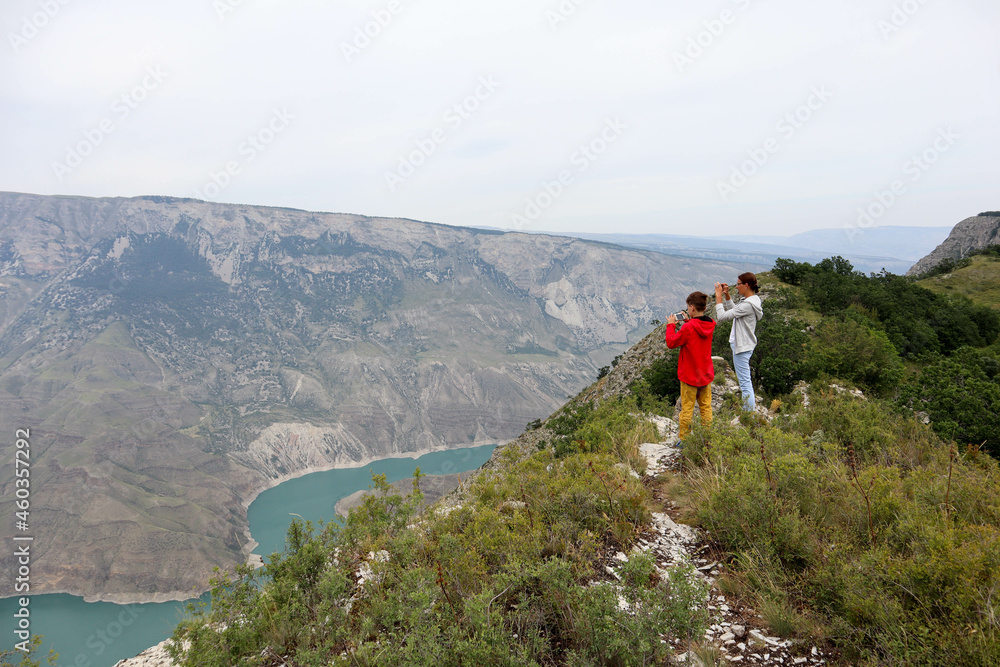 mother and son take a photo of the scenic Sulak canyon in Dagestan