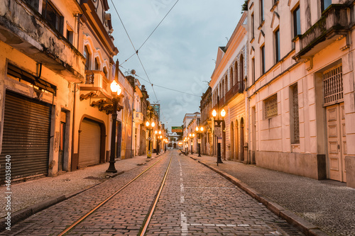 Old center of the city of Santos. Street of trade. Stone street, facades of old houses, old cast iron poles with yellow light and in the background the church of Valongo. © Stefan Lambauer