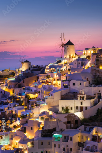 Oia village, Santorini, Greece. View of traditional houses in Santorini. Small narrow streets and rooftops of houses, churches and hotels. Landscape during sunset. Travel and vacation photography.