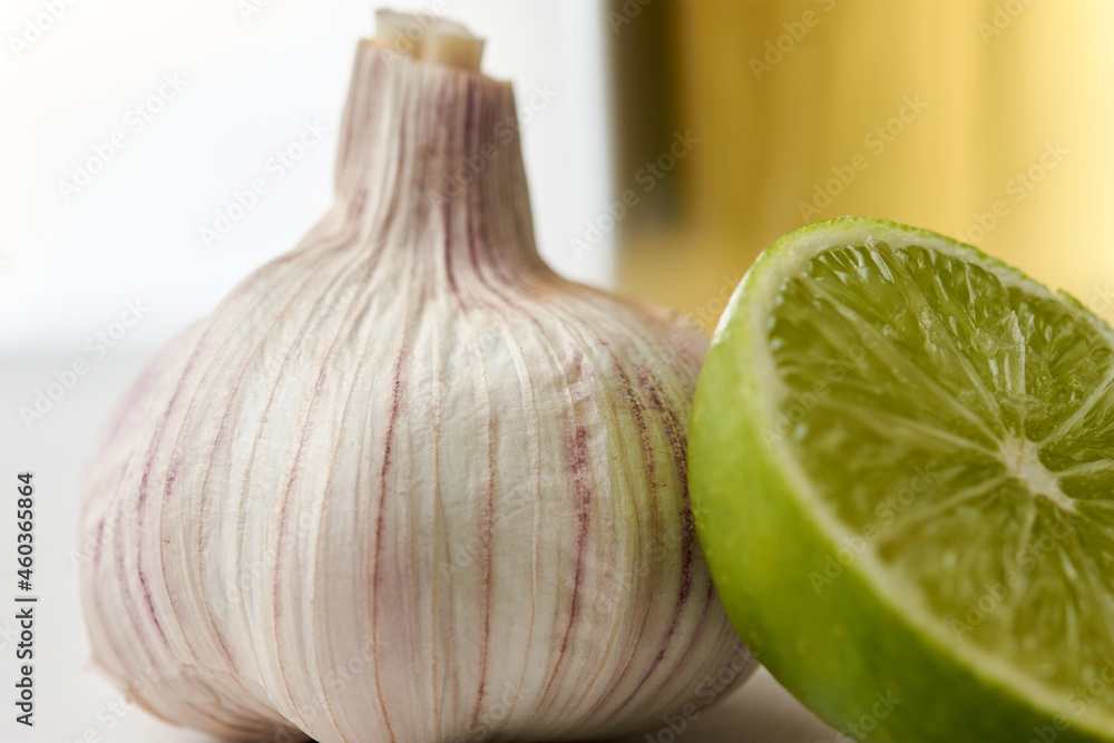 Obraz premium Infusion or tea of lemon and garlic, in a glass and placed on a white tablecloth