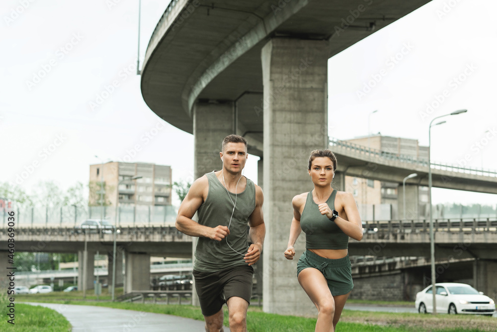 Sportive couple during jogging workout on city street