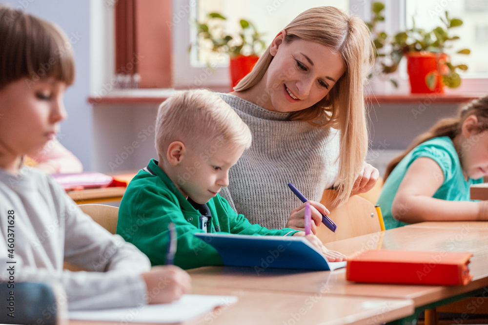 Young pretty teacher solves homework together with the student Young pretty teacher solves homework together with the student