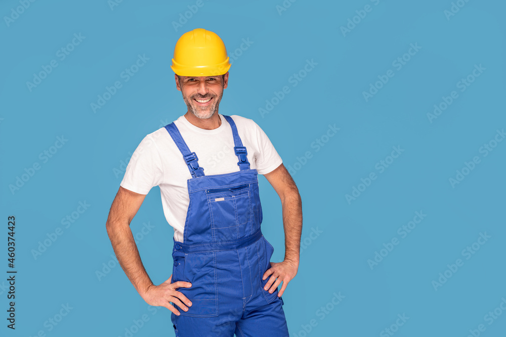 Handsome man industrial engineer wearing a yellow helmet, isolated on blue pastel studio background. Handsome man industrial engineer wearing a yellow helmet, isolated on blue pastel studio background.