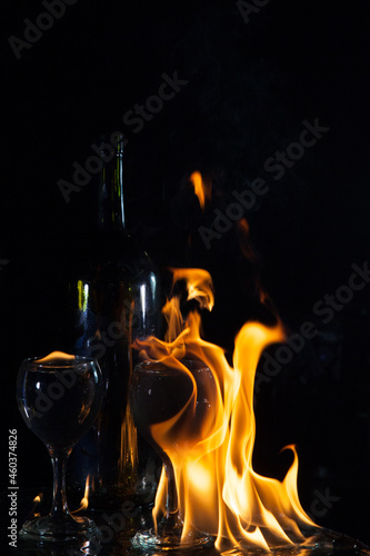 Two glasses and bottle in a flame