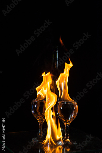 Two glasses and bottle in a flame