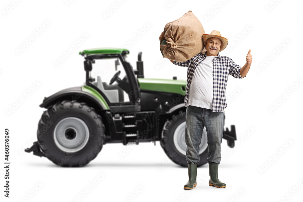 Full length portrait of a happy mature farmer gesturing thumbs up in front of a tractor Full length portrait of a happy mature farmer gesturing thumbs up in front of a tractor