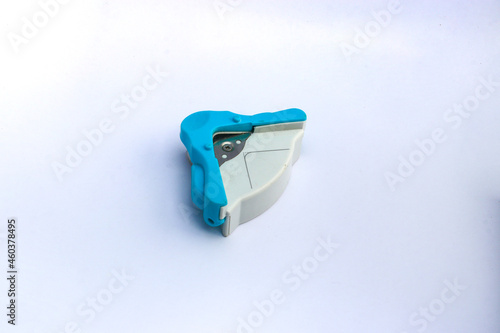 Blue and white corner cutter rounder punch for cutting card photo paper. Isolated on white background.