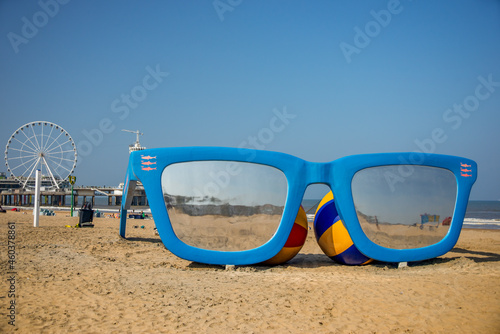 03 September 2021, Scheveningen beach, The Hague, Netherlands, model of  cun glasses on the sand with beach balls photo