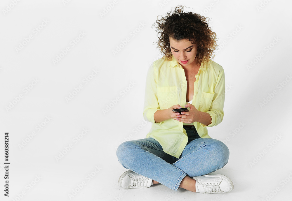 Young woman with mobile phone posing on light background Young woman with mobile phone posing on light background