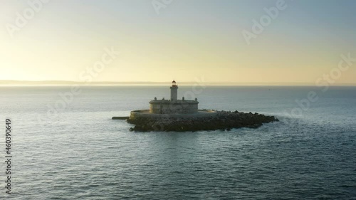 Lisbon. Portugal. A prominent landmark of the Forte do Bugio lighthouse set offshore. Drone footage of picturesque coast under sunset sky. High quality 4k footage photo