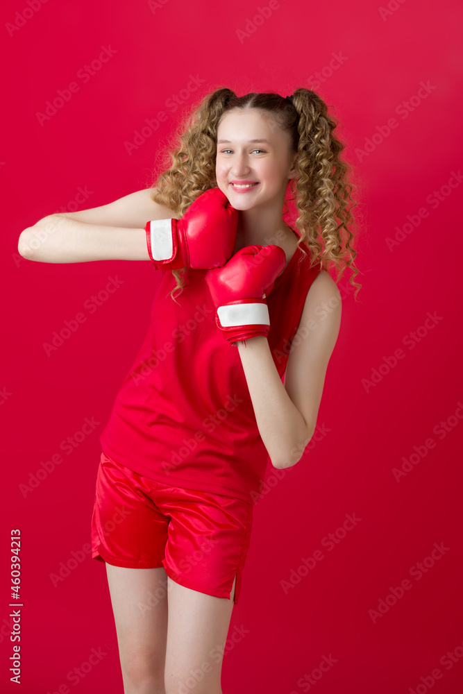 Pretty teen girl fighting with red boxing gloves Pretty teen girl fighting with red boxing gloves