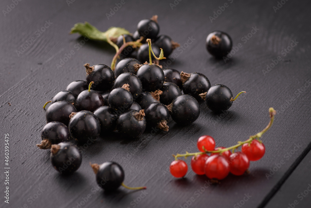 black currant lies on a black wooden surface black currant lies on a black wooden surface