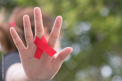 hand holding red ribbon of world aids day
