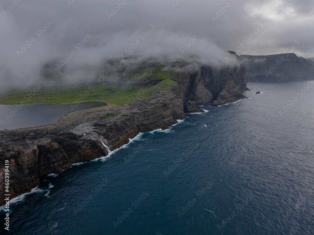 Beautiful aerial view of the Bøsdalafossur waterfall and Trælanípan magnificent landmarks in the Faroe Islands