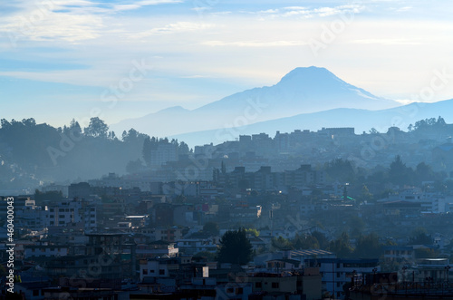 Quito in blue morning haze with fog and Cayambe volcano in background, Quito, Ecuador.