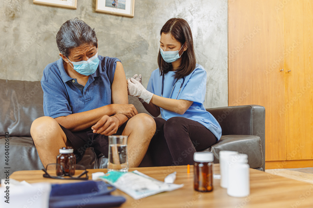 Obraz premium Health visitor and a senior woman during home visit.elderly senior woman and a female nurse show that they are in favor of a vaccination, concept pandemic and coronavirus protection