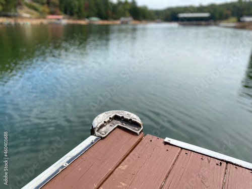 The corner edge of an old dock by a lake.