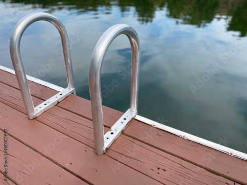 A swim ladder on an old dock by the lake.