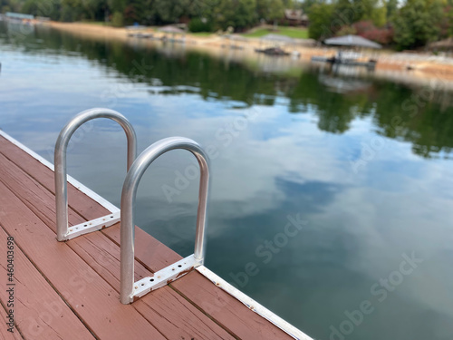 A swim ladder on an old dock by the lake.