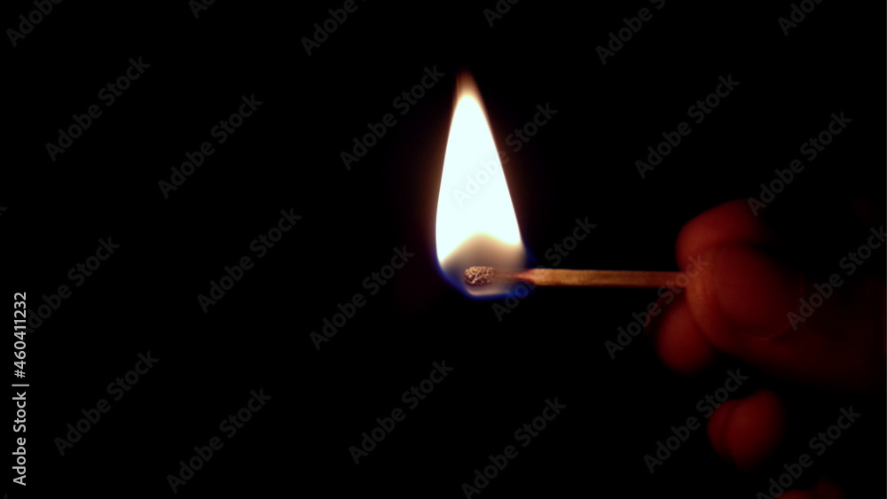Lone burning match with the flame in the upper left side of the frame isolated on black background Lone burning match with the flame in the upper left side of the frame isolated on black background